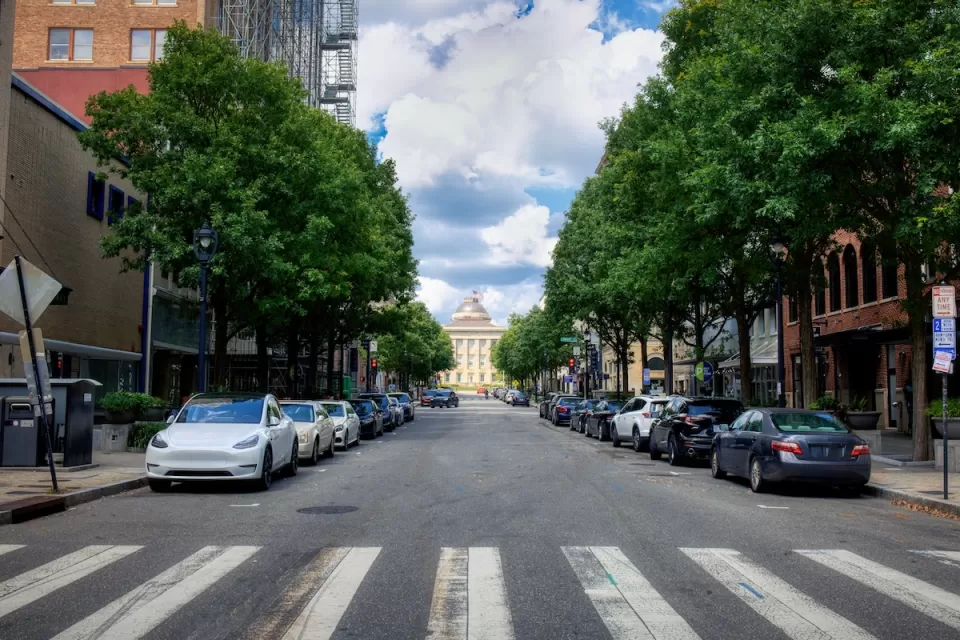 Crosswalk on street in Raleigh, North Carolina with parking on both sides and capitol building visible in background.